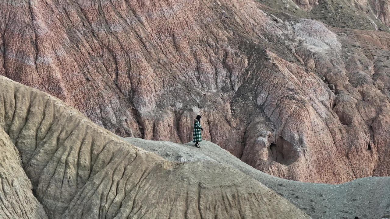 美女举起相机拍照在丹霞地貌