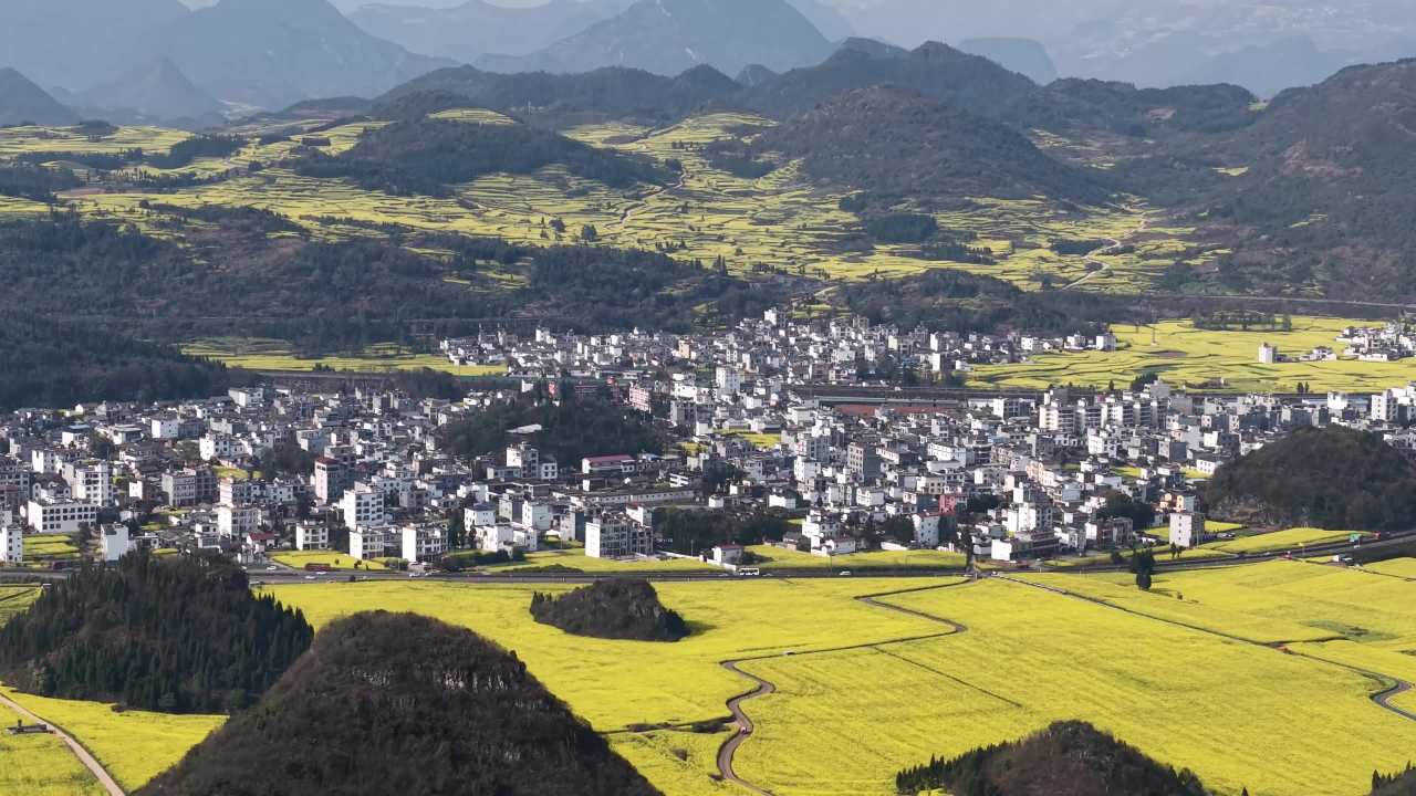 山间油菜花与村庄的和谐美景