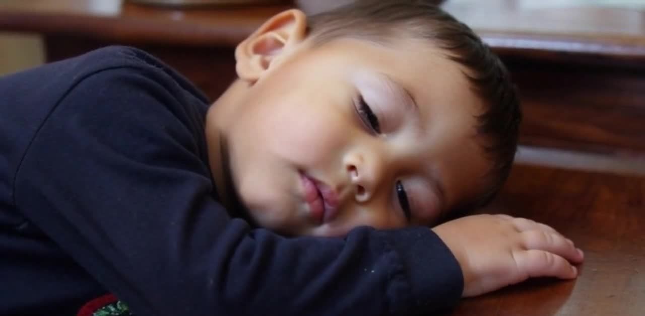 熟睡的幼童趴在桌上休息