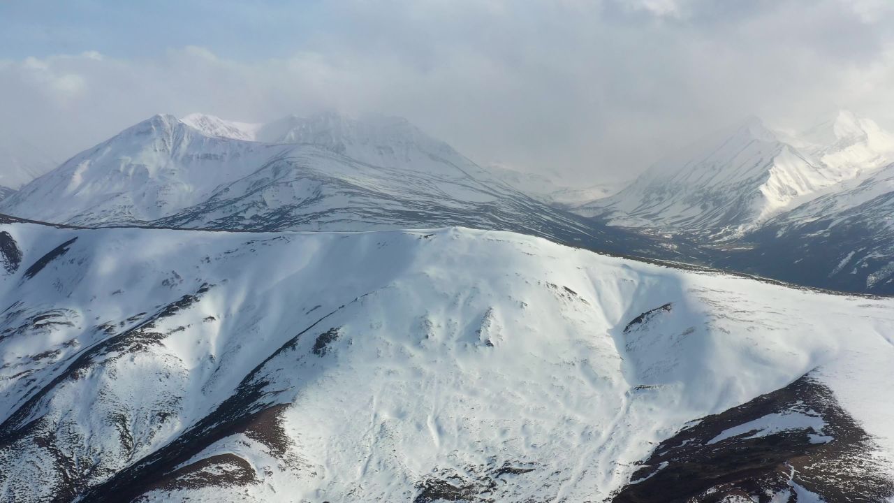 航拍风雪中的西藏洛隆县雪山风光
