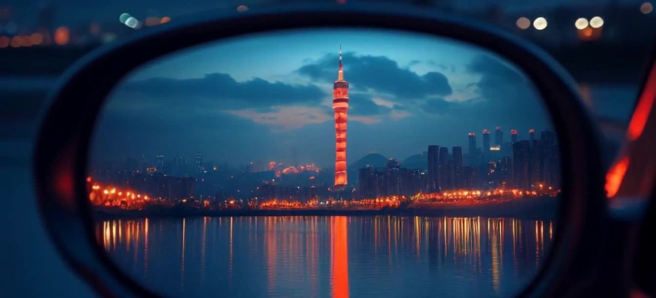 后视镜中，一座高耸的塔楼矗立在水边，塔楼呈红白相间