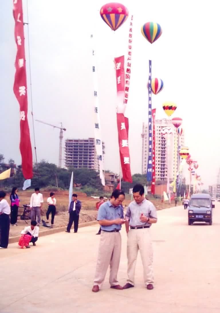 在马路上，两个人正在交谈，其中一人似乎在记录。空中