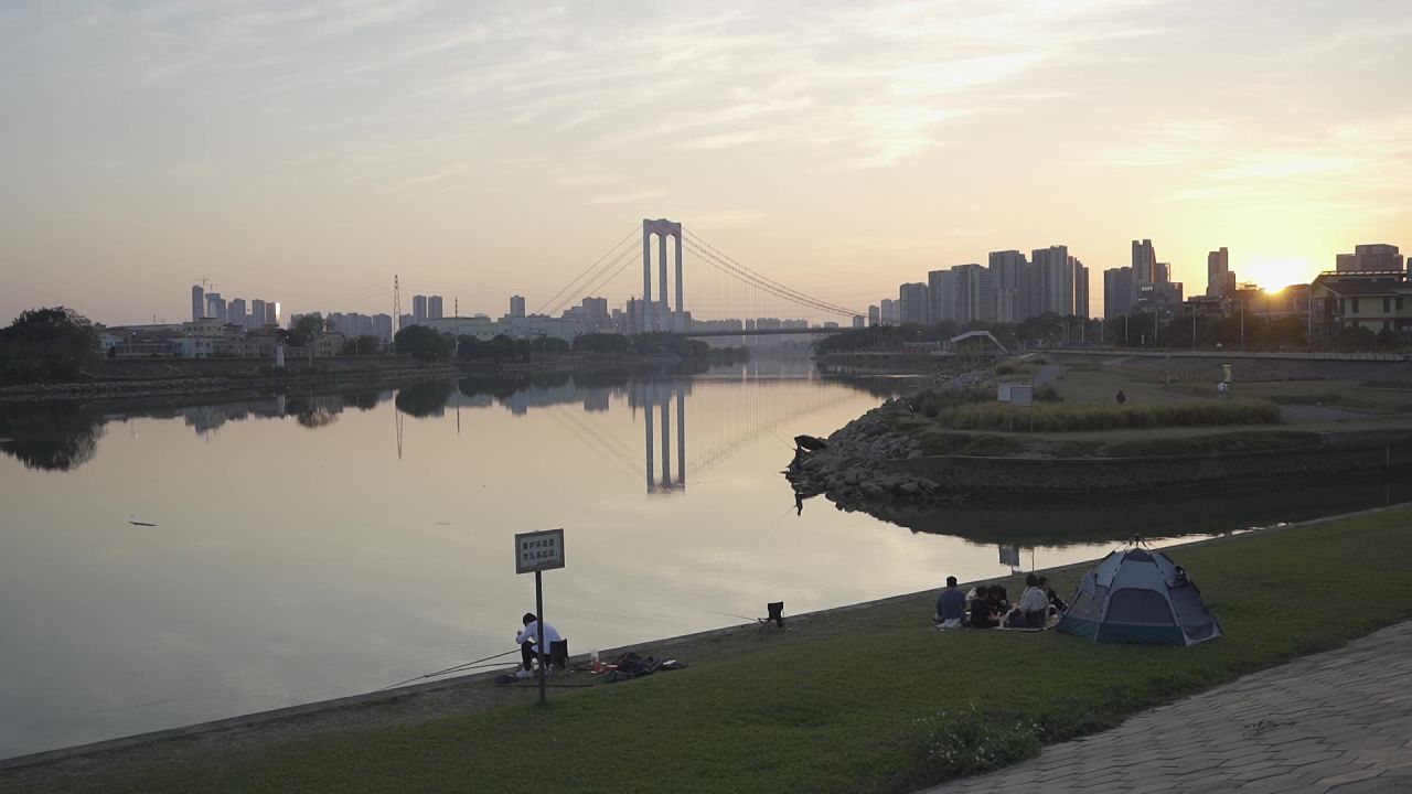 夕阳下城市水库旁休闲的人们