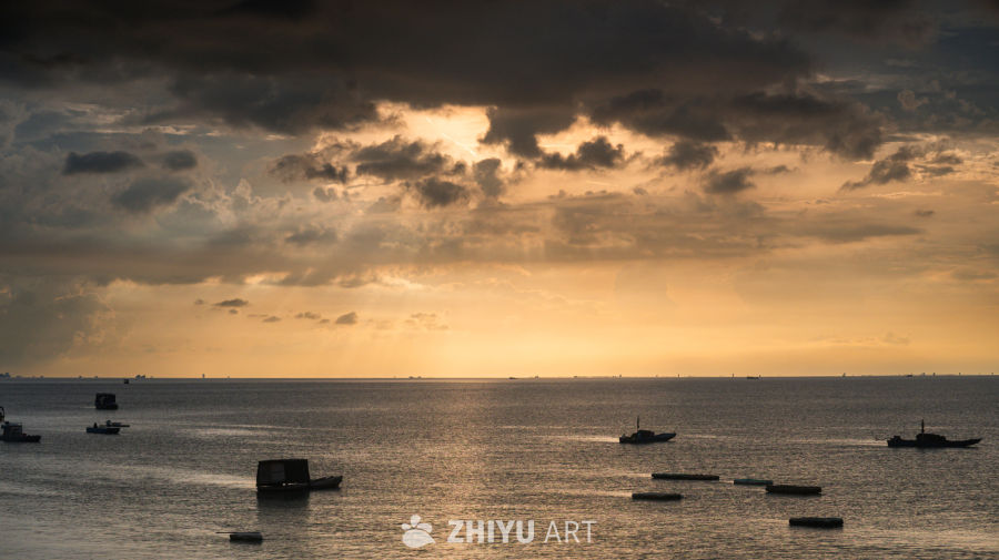 金色日落下的渔船海景