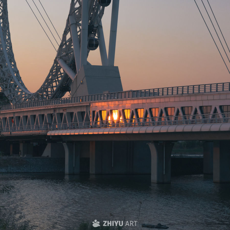 夕阳下的桥梁与摩天轮
