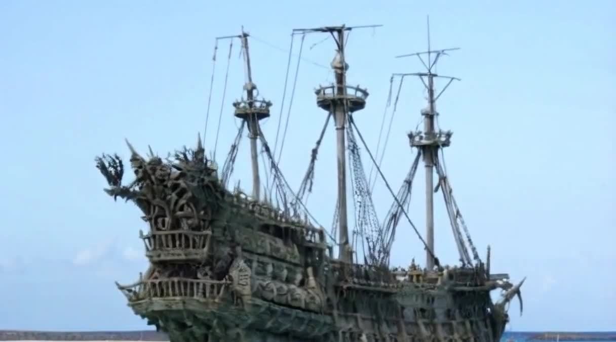 一艘大型木制帆船漂浮在海面上，船体呈现出腐朽的质感