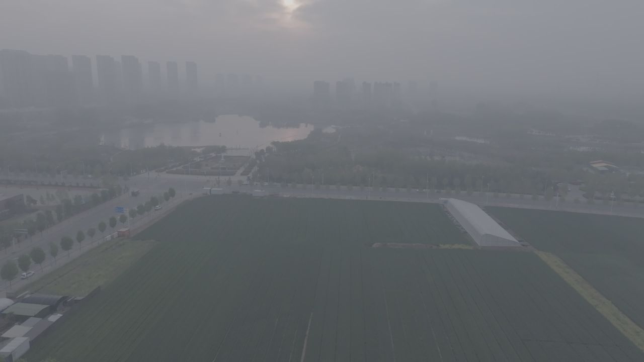 晨雾中的城市与农田