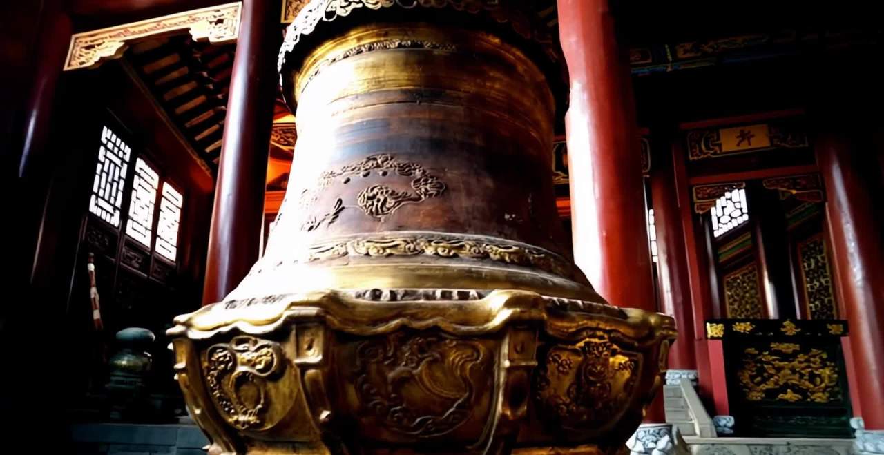 一个中式寺庙内部，一个巨大的铜钟位于画面中心，钟体