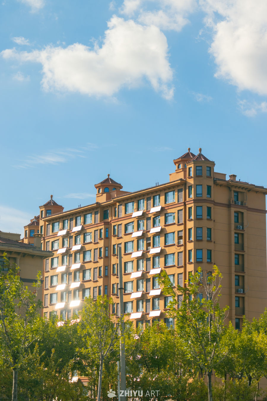 橙色高楼与绿树蓝天