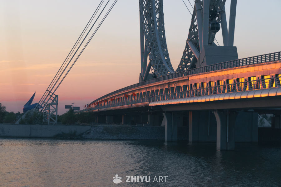 夕阳下的桥梁与摩天轮