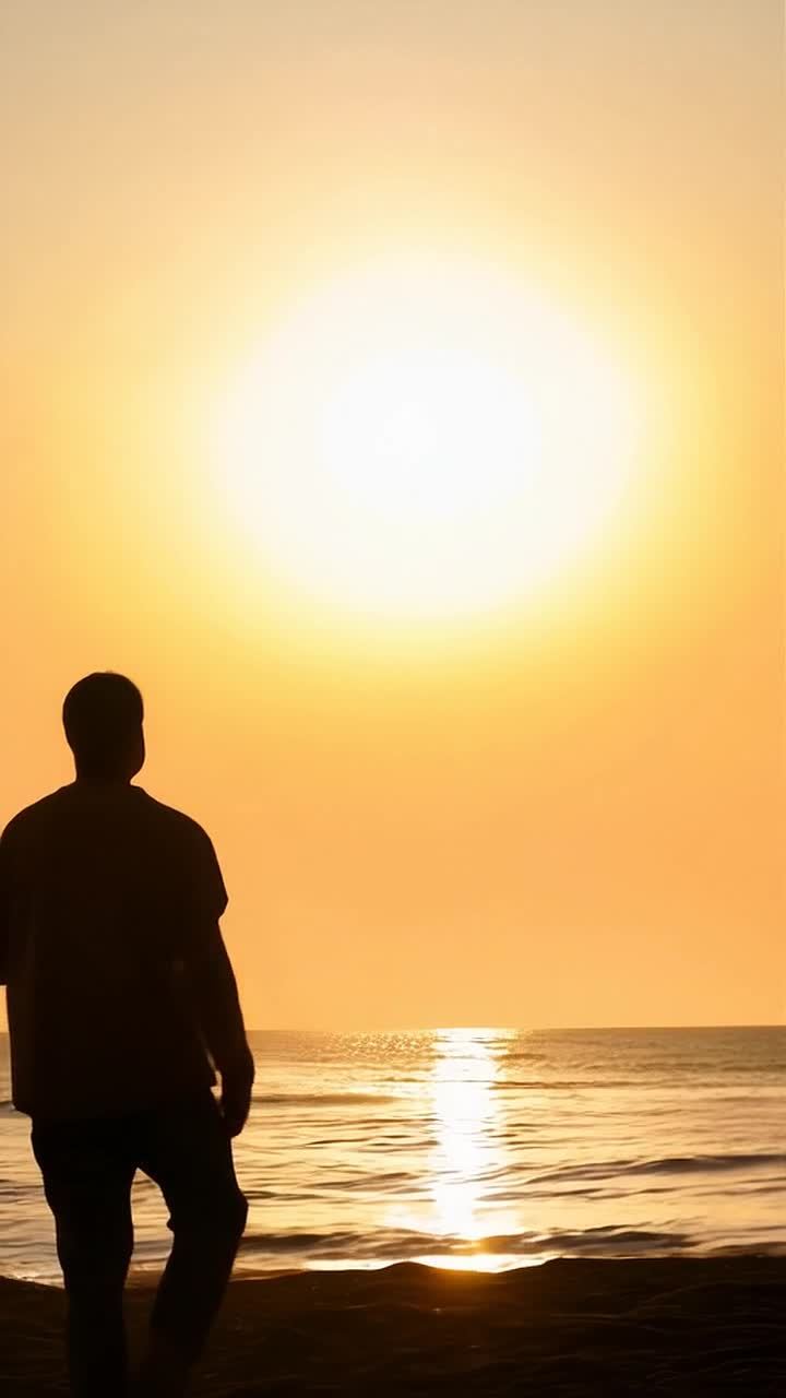 一个人站在海边的沙滩上，面向前方发光的太阳，太阳在