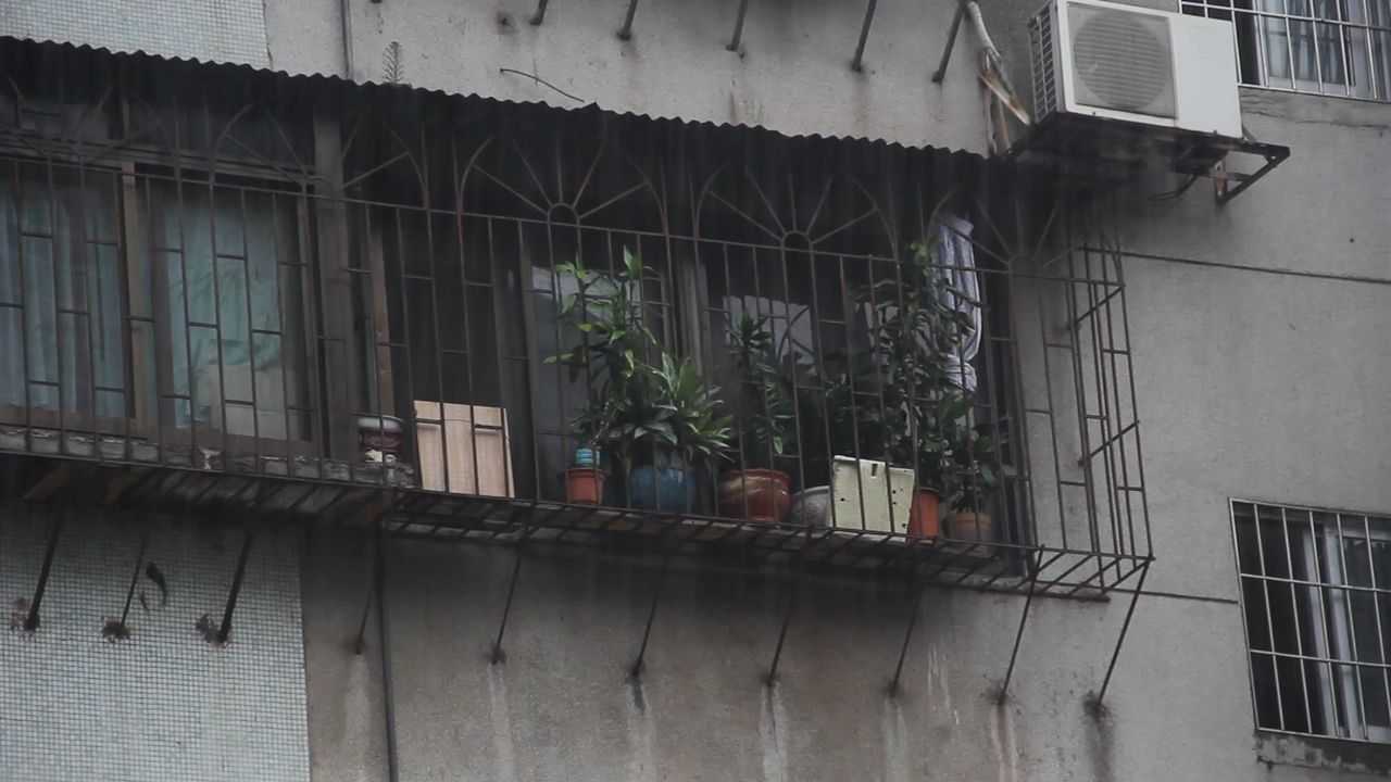 大雨中的居民楼窗户和防盗网